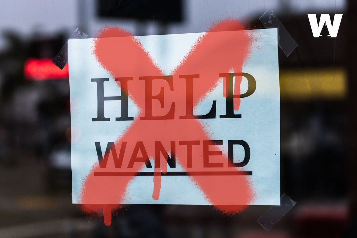 A ‘Help Wanted’ sign in a window, crossed out with a red X.