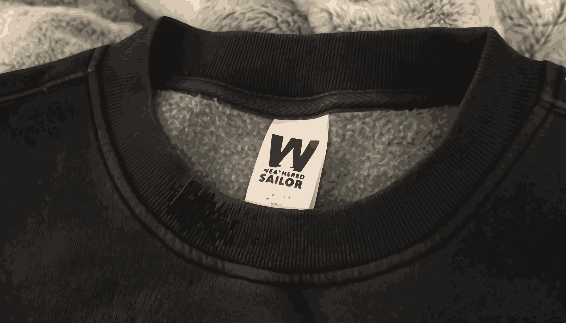 A close-up illustration of a black Weathered Sailor sweatshirt collar and woven neck label.