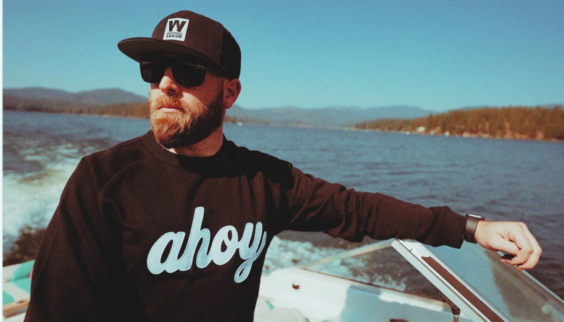 Aaron "Chuck" Fulmer, the founder, out on a mountain lake wearing the ahoy crew and a Weathered Sailor cap.